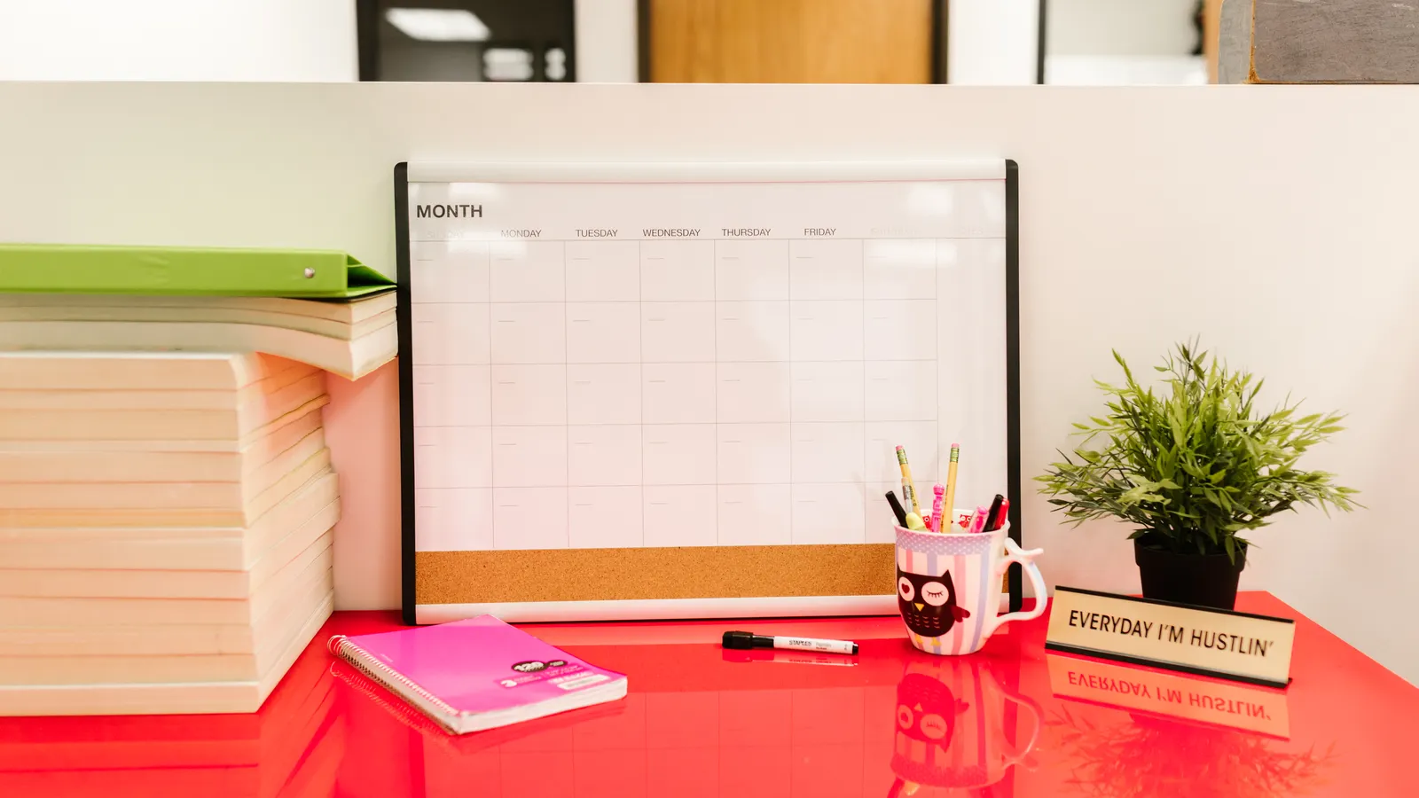 A calendar, books, and stationery arranged on a desk