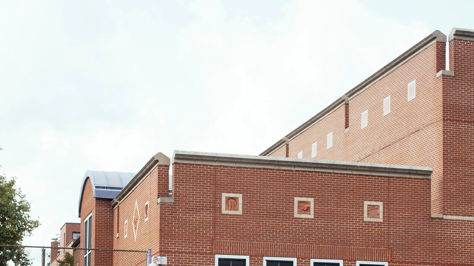 Exterior of a brick school building beside an athletic field