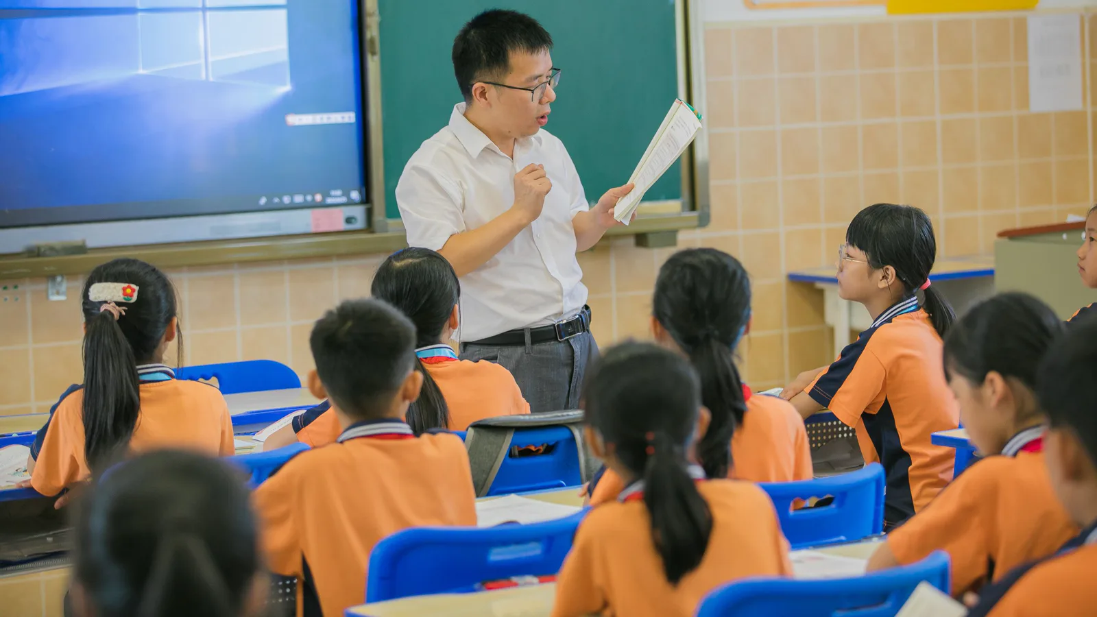 Teacher speaking to students seated in a classroom