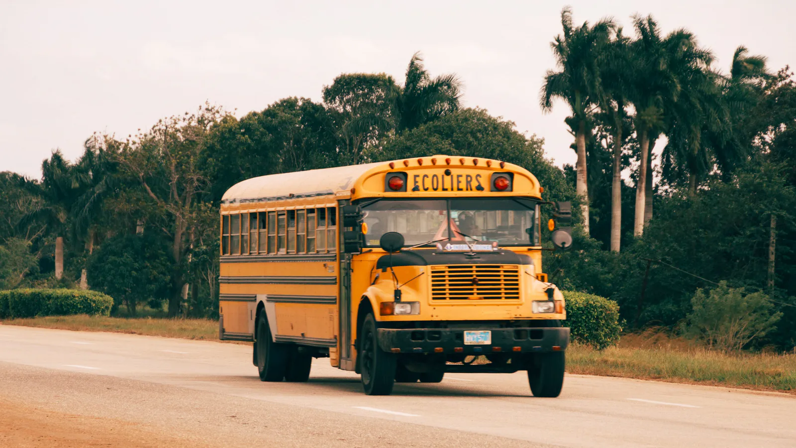 Yellow school bus traveling along a rural road